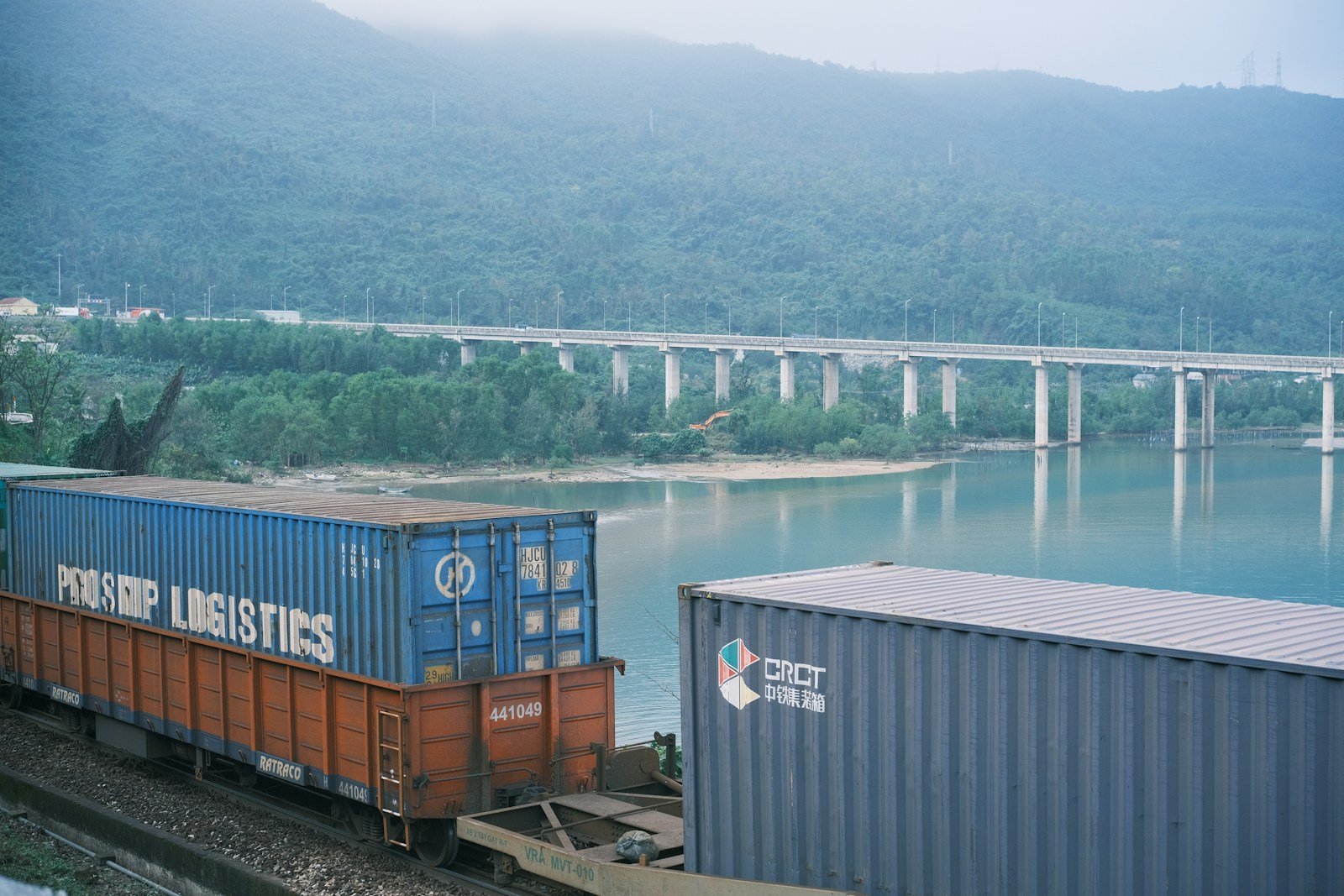 A train traveling down tracks next to a body of water