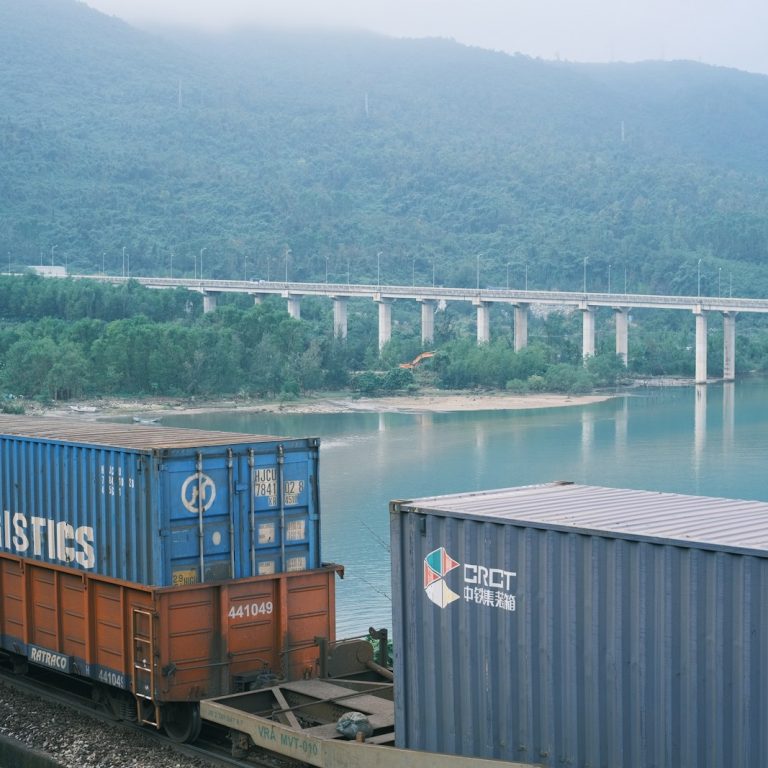 A train traveling down tracks next to a body of water